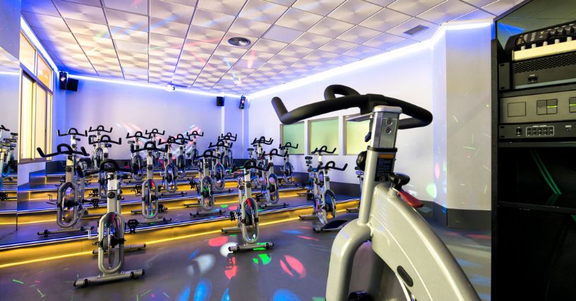 Sala rowerowa w klubie fitness z rowerami spinningowymi ustawionymi na podwyższeniu