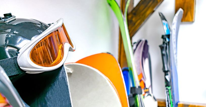Gogle, narty i deski snowboardowe przygotowywane do schowania
