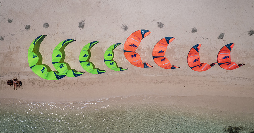 Kolorowe latawce do kitesurfingu ułożone na plaży