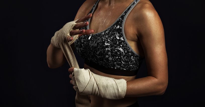 Kobieta zakładająca owijki bokserskie na ręce