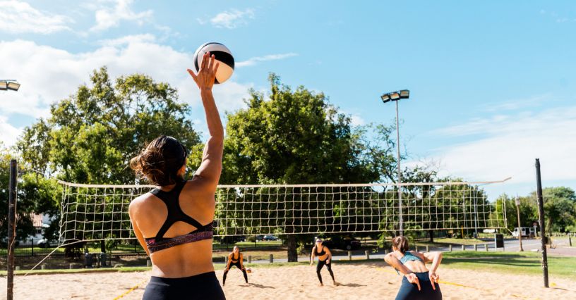 Kobieta zagrywka piłkę podczas gry w siatkówkę plażową