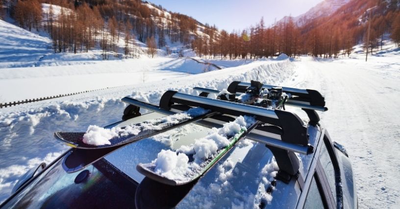 Narty przypięte do bagażnika na dachu samochodu