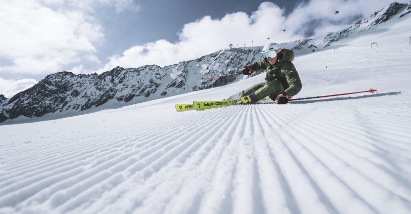 Narciarz zjeżdżający z kijkami po stromym stoku