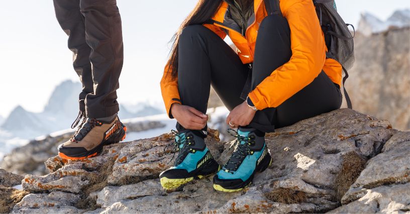 Kobieta i mężczyzna w butach trekkingowych Scarpa na skale