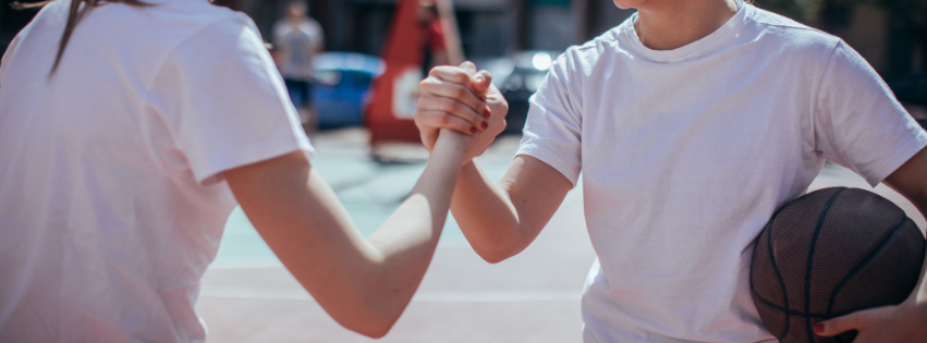 Uścisk dłoni dziewczyny grających w koszykówkę