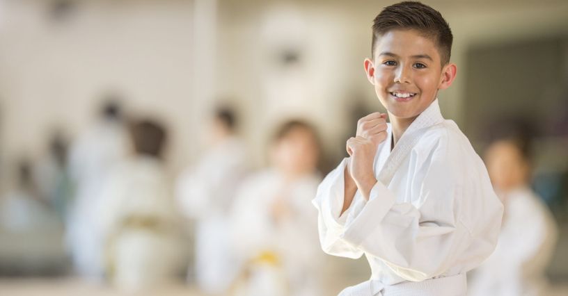 Młody karateka stojący z zaciśniętymi pięściami