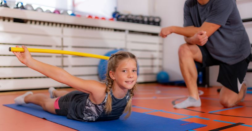 Dziewczynka w stroju sportowym podczas gimnastyki korekcyjnej dla dzieci