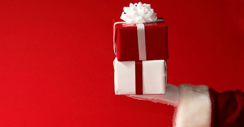 Dwa prezenty ułożone na sobie na dłoni Mikołaja