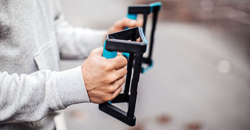 Mężczyzna trzymający w dłoniach uchwyty do pompek