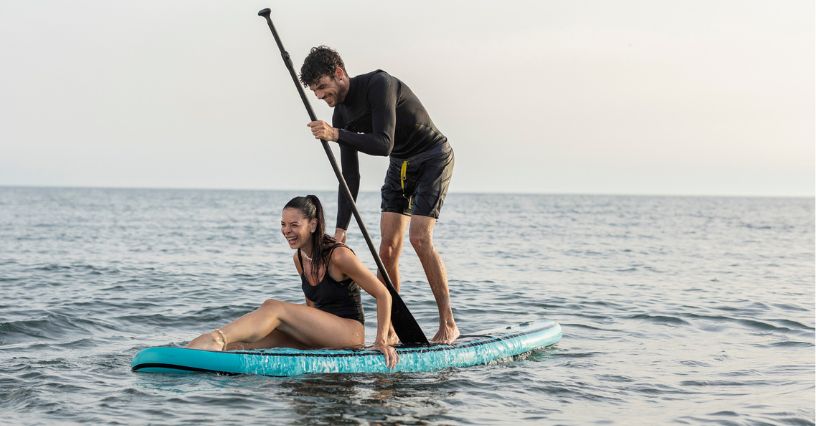 Para pływająca na desce SUP po morzu