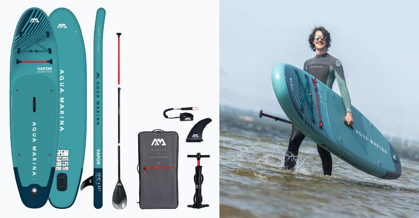 Deska SUP Aqua Marina Vapor 10’4″ i mężczyzna w piance neoprenowej wnoszący ją do wody