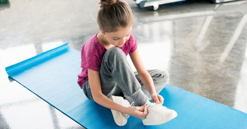 Dziewczynka wiąże trampki, idealne do szkoły i na co dzień
