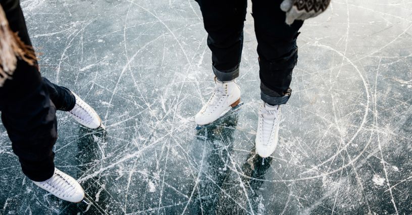 Para łyżwiarzy w łyżwach figurowych podczas jazdy na lodowisku otwartym