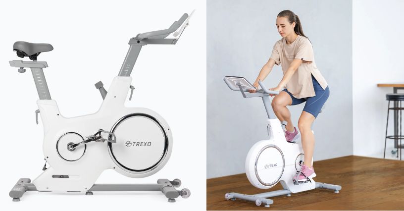 Kobieta w stroju sportowym jadąca na rowerze spinningowym TREXO EB500 w pokoju