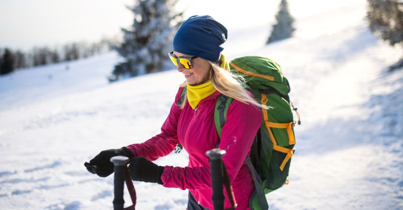 Kobieta w zimowej czapce z wełny merino na śnieżnym szlaku