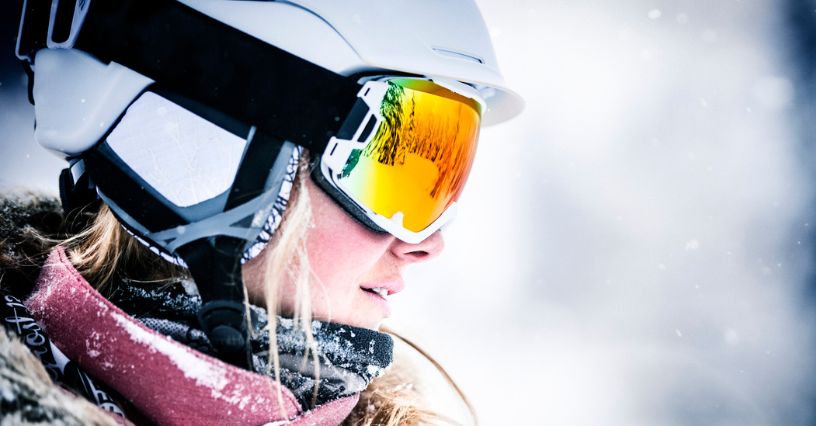 Narciarka w goglach na stoku w zimowej scenerii