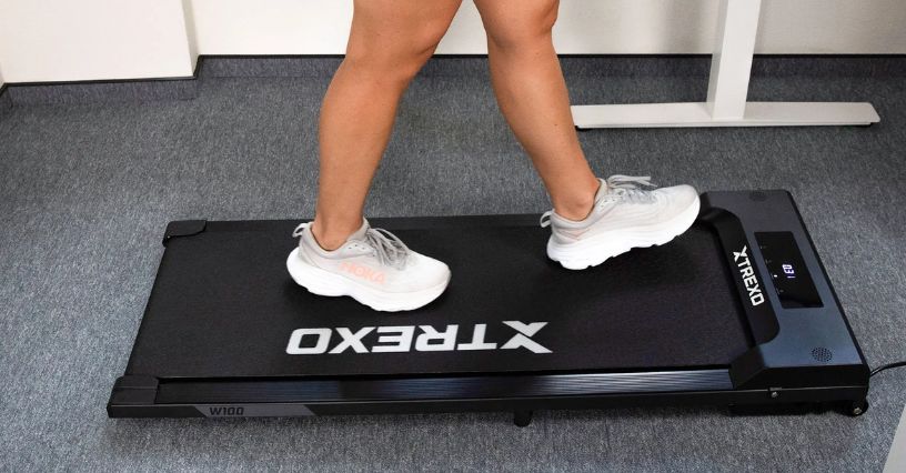 Osoba spaceruje na walking padzie podczas pracy przy biurku