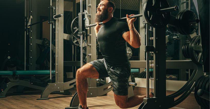 Mężczyzna ćwiczy na maszynie Smitha w domowej siłowni