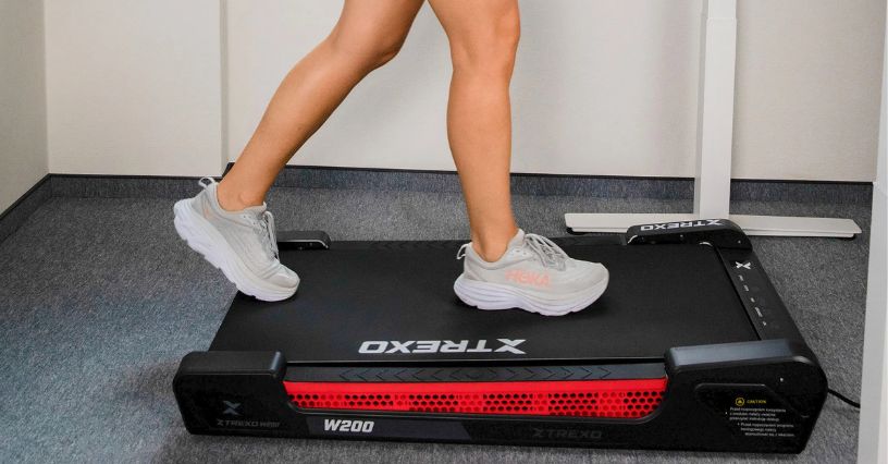 Osoba chodzi na bieżni o optymalnej prędkości 2-3 km/h podczas pracy 