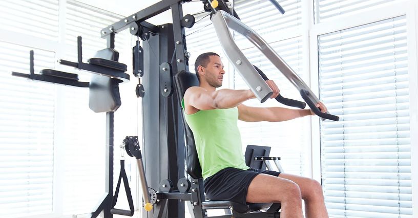 Mężczyzna ćwiczy na atlasie w domu