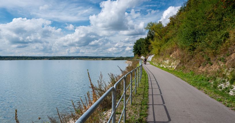 Rowerzysta jedzie po ścieżce rowerowej przy Jeziorze Czorsztyńskim